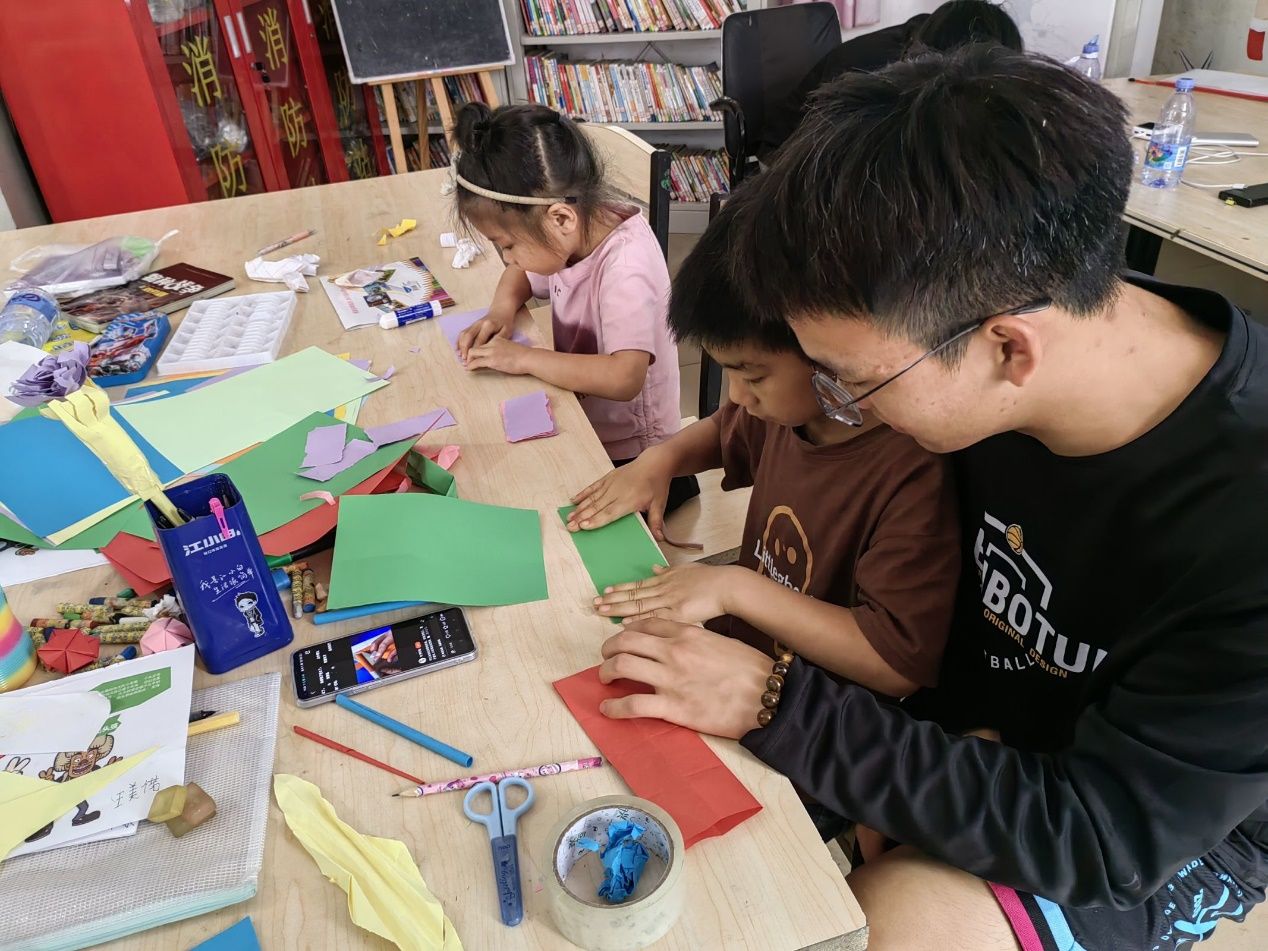 男孩看着桌子上低可信度描述已自动生成